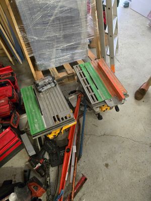un homme debout à côté d'un tas d'outils