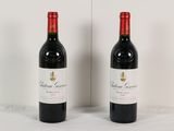 two bottles of red wine sitting next to each other on a table