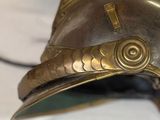 a gold helmet on a table with a hat on top of it