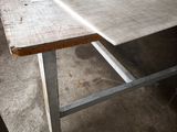 une longue table avec un plateau en bois et des pieds en métal