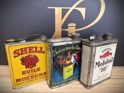 three vintage shell oil cans sitting on top of a wooden table