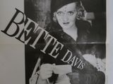 une vieille affiche de cinéma représentant une femme tenant un chat dans ses bras