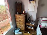 a bedroom with a bed, dresser, and a window