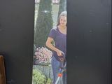 Une femme se tient devant un carton contenant une tondeuse à gazon.