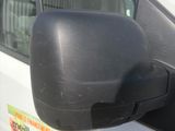 a side view mirror of a white van with a sticker on it