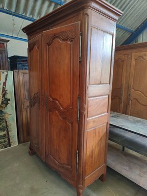 a wooden armoire in a room with a mattress on the floor