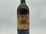 une vieille bouteille de vin posée sur une table blanche