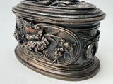 a silver box with a bird and flowers design on it