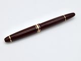 un gros plan d'un stylo sur une surface blanche avec un fond blanc