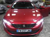 l'avant d'une voiture rouge dans un garage où se trouvent d'autres voitures