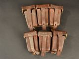 six tan leather magazine pouchs on a gray background