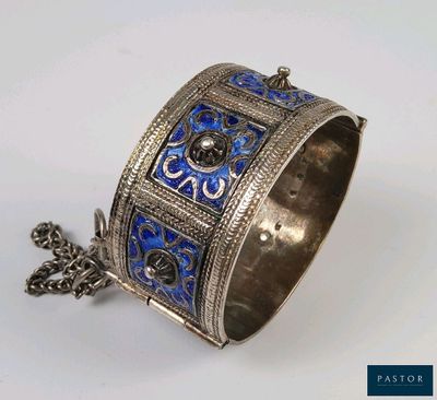 un gros plan d'un bracelet à chaîne posé sur une surface blanche