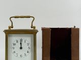 a small clock sitting next to a box on a table