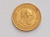 a close up of a gold coin on a white surface