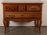 a wooden chest of drawers with marble top