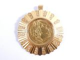 une médaille d'or sur laquelle figure l'effigie d'un homme