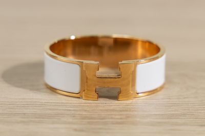 a close up of a white and gold ring on a wooden surface
