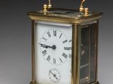 a small brass clock with a key next to it