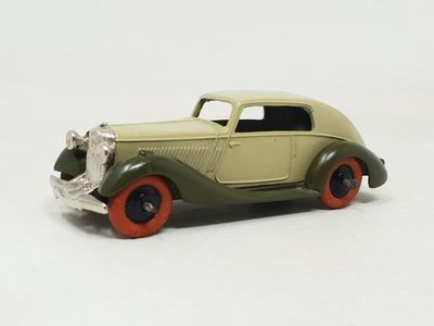 a green toy car with red wheels on a white surface