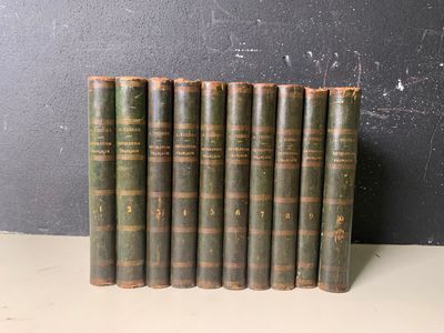 six vieux livres alignés sur une étagère adossée à un mur noir