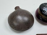 a small bottle and a small container sitting on a table