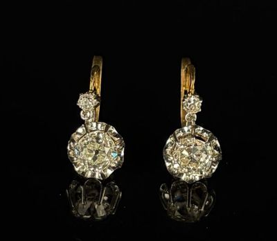 une paire de boucles d'oreilles en diamant sur une surface noire