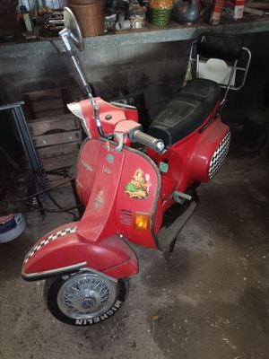 a red scooter that is parked in a garage