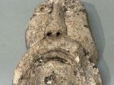 a stone sculpture of a face on a table