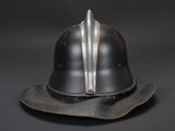 an old helmet is sitting on top of a hat on a black surface