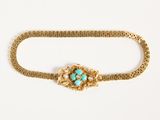 deux bracelets en or ornés de pierres de turquoise, posés sur un fond blanc