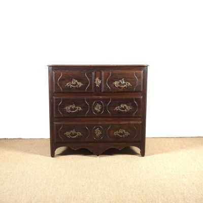 une petite commode posée sur un sol recouvert de moquette