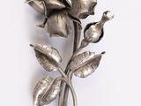 une broche en forme de fleur argentée sur un fond blanc