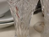 two glass vases sitting on a table next to a plate