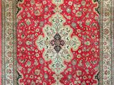 a red and black rug with a medallion design on it