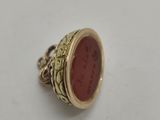 a close up of a gold ring with a red stone in it