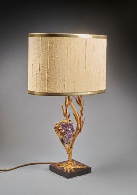 une photo d'une lampe de table avec un pied doré et une pierre violette