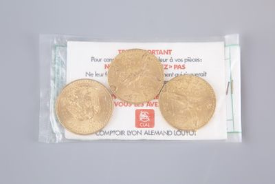 three gold coins in a plastic bag on top of a table