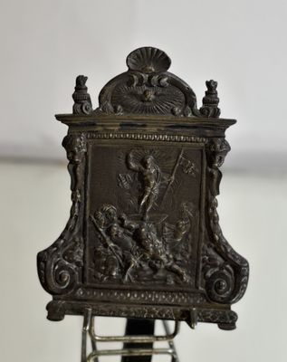 a metal clock that is sitting on a stand