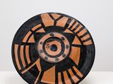 an orange and black plate sitting on top of a white table