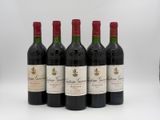 four bottles of red wine are lined up on a white surface