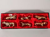 une boîte rouge contenant six figurines argentées