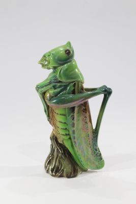 une figurine représentant une grenouille assise sur une souche d'arbre