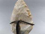 a close up of a rock on a metal stand with a cloudy sky in the background