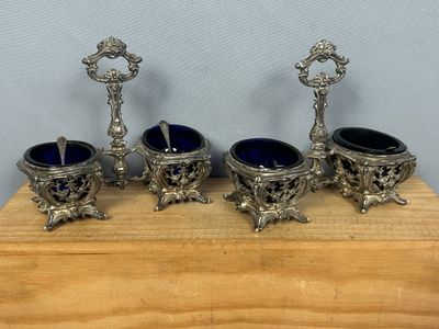 three silver and blue glass vases sitting on a wooden stand