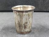 a close up of a silver cup sitting on a table