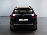 the rear end of a black suv parked in a room