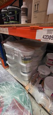 de nombreux pots de peinture sur les rayons du magasin