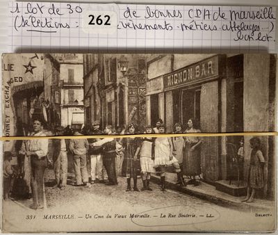 une vieille photo montrant un groupe de personnes debout devant un magasin