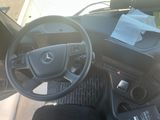 a steering wheel and dashboard of a car with papers on the dashboard