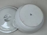 a white bowl with a lid sitting on a table
